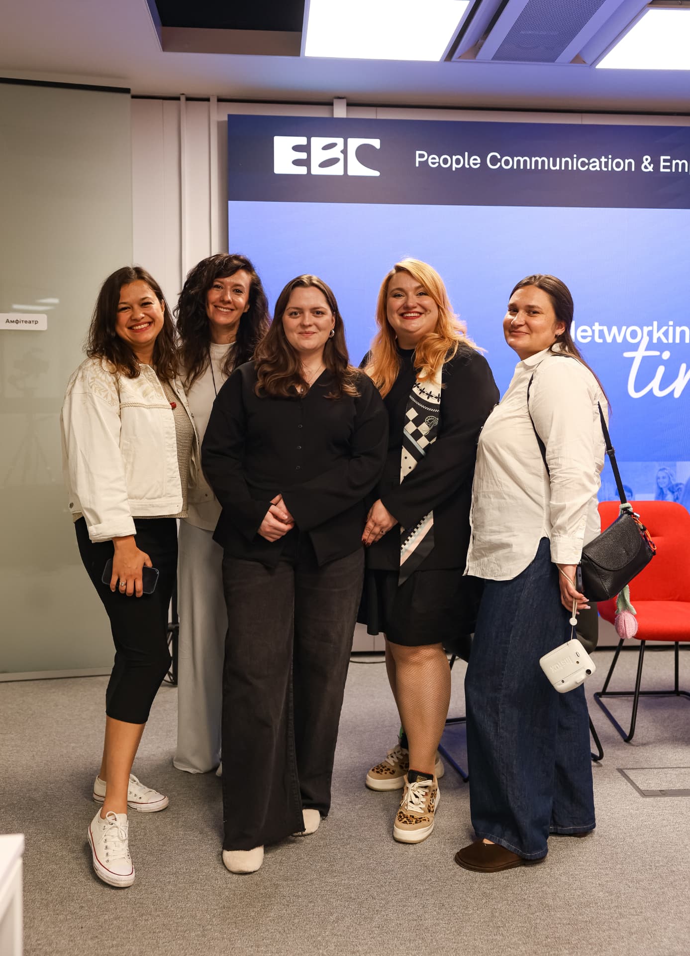 Five guests posing in front of the EBC stage screen