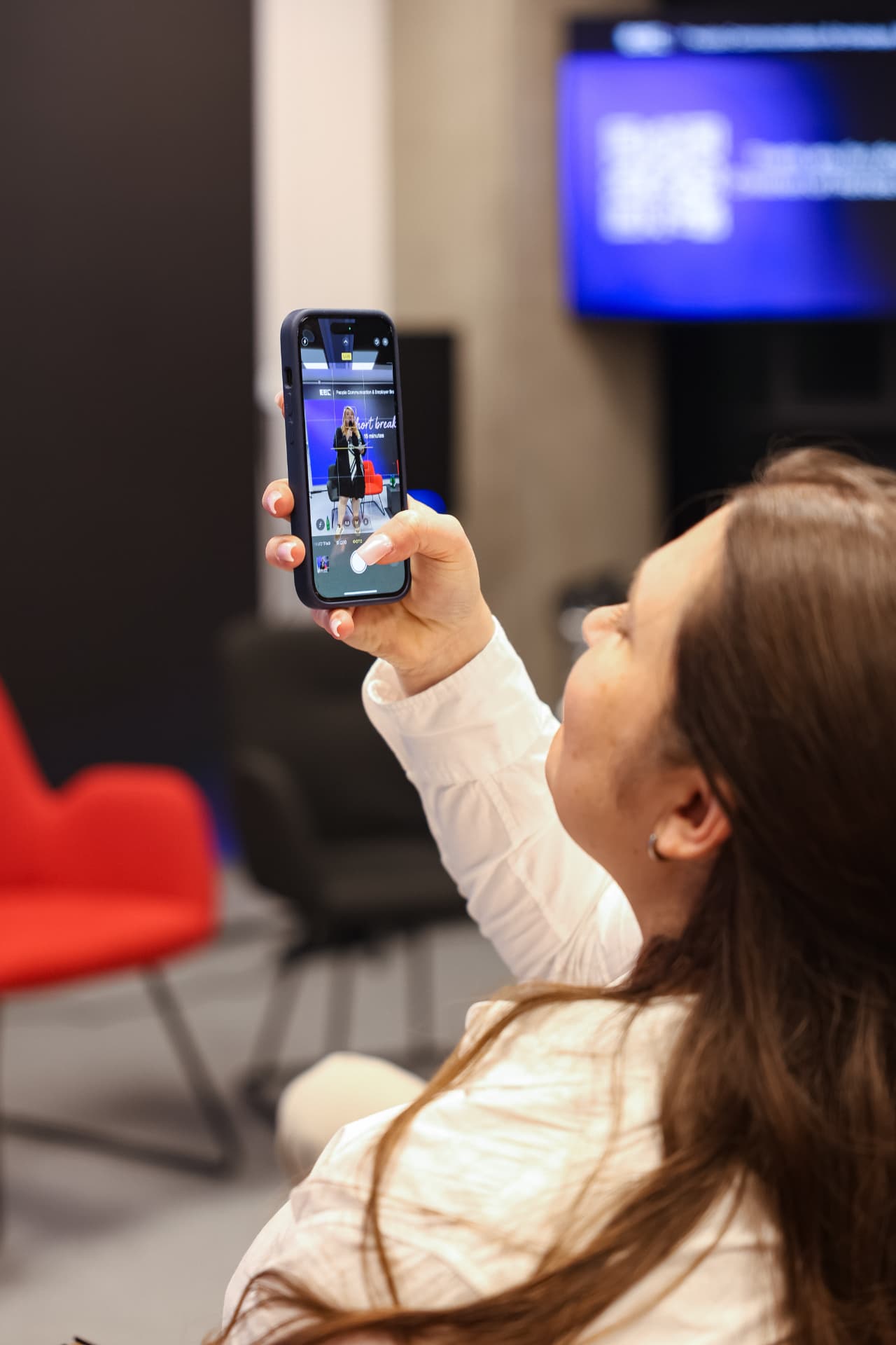 A guest photographing the stage on her phone