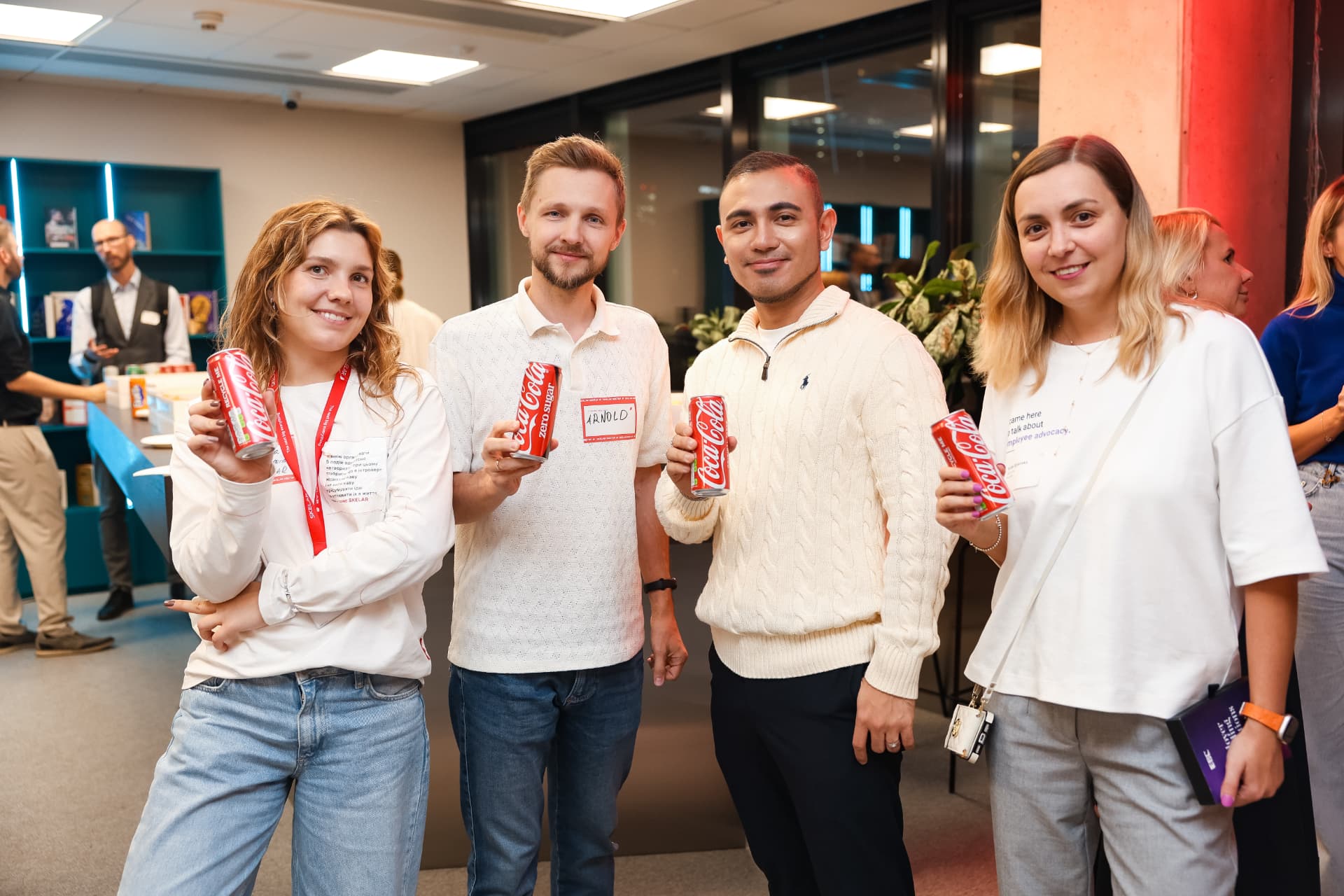Guests raising Coca-Cola cans during networking