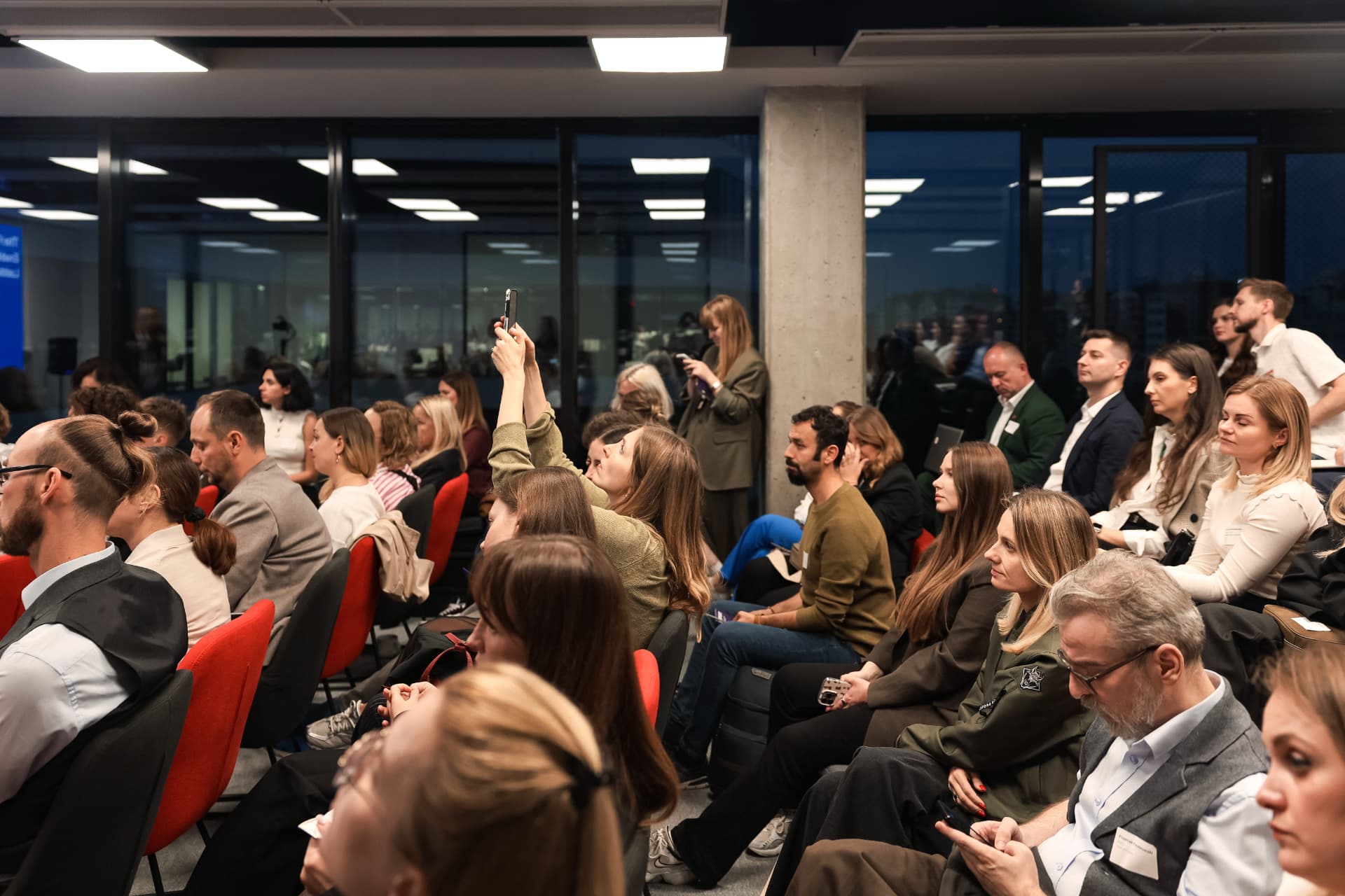 Audience listening, one guest photographing the stage
