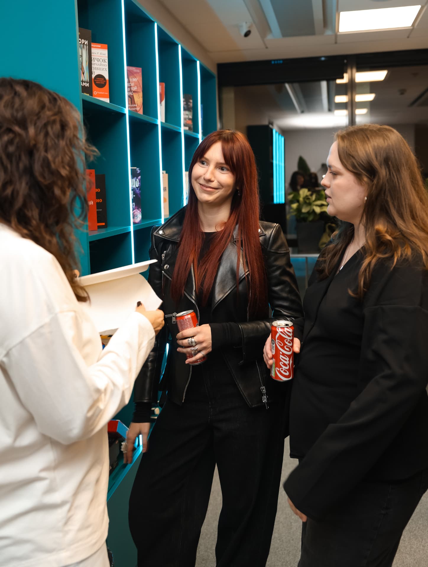 Guests chatting by the bookshelf with drinks